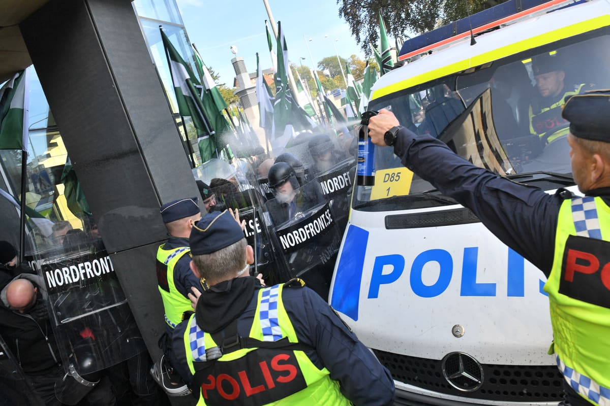 Poliisit käyttävät pippurisumutettaa mielenosoittajia vastaan.