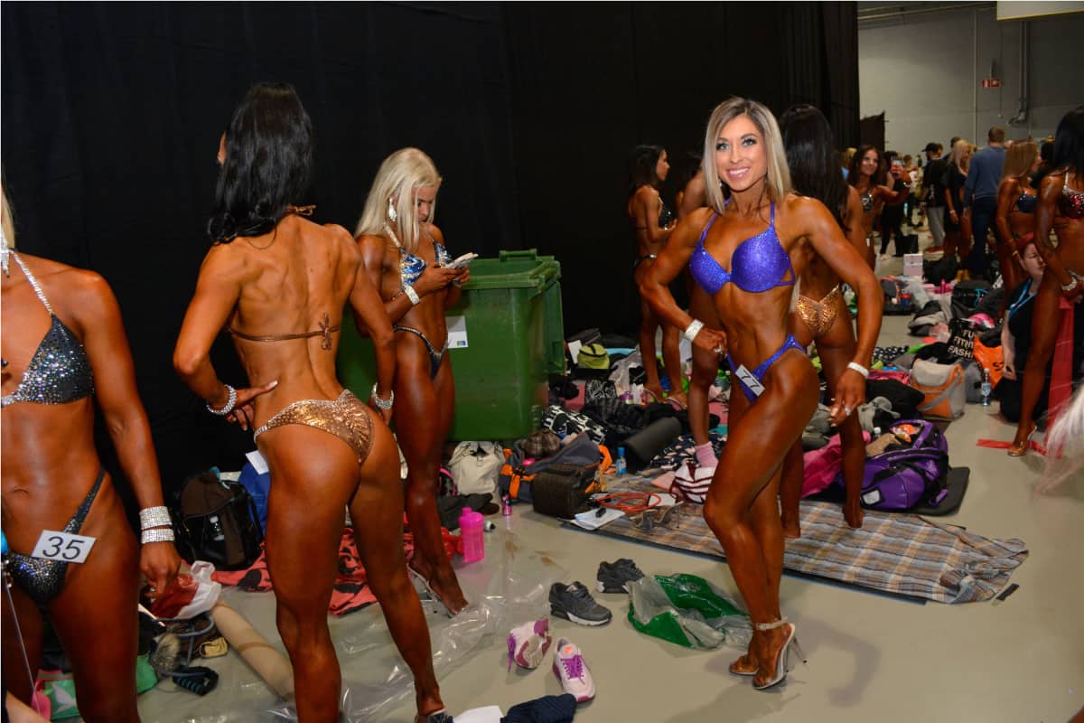 Bikini fitness -kilpailijoita valmistautuu vuoroonsa lavan takana.