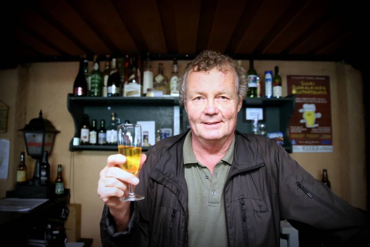 Mies kohottaa siiderilasia