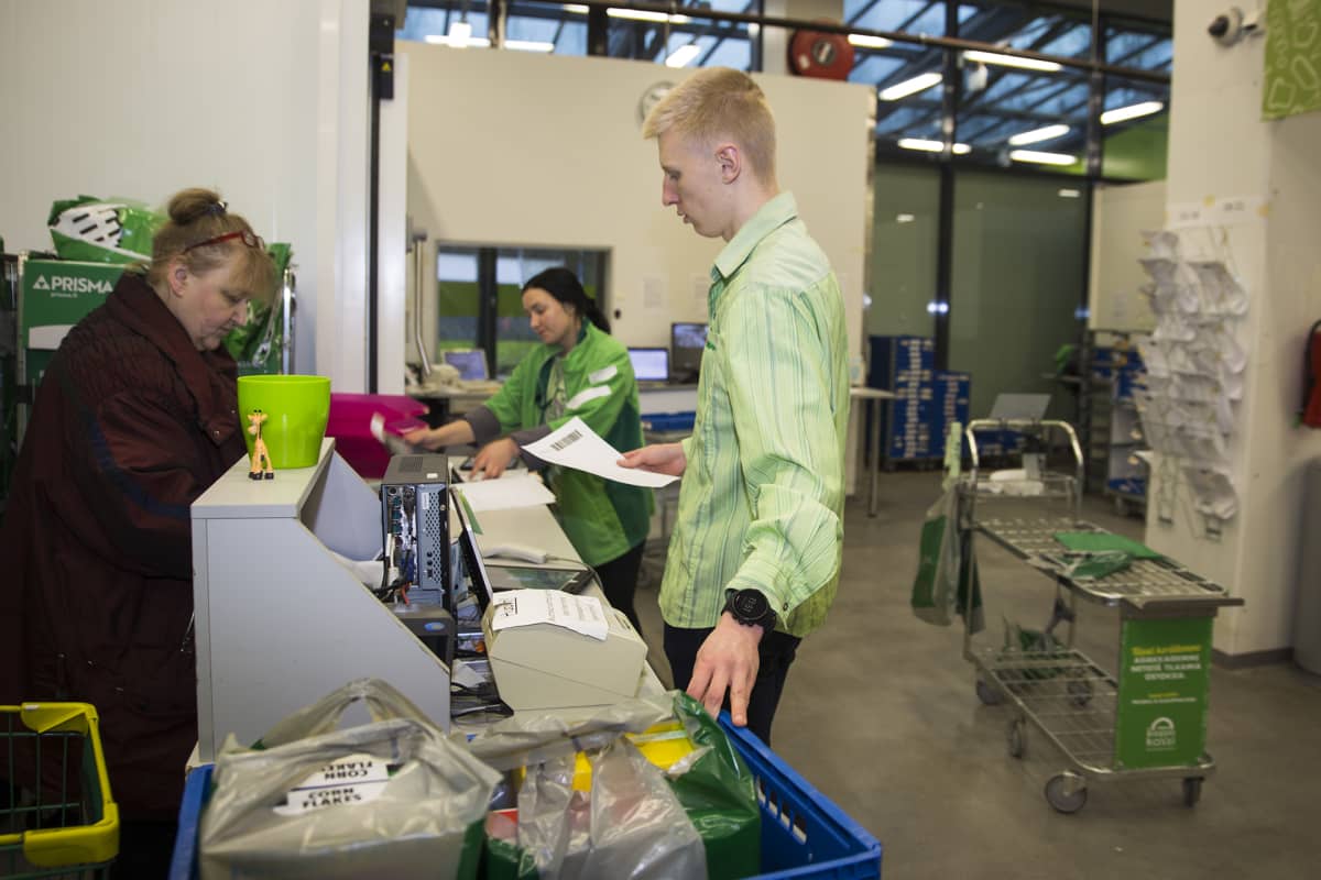 Työntekijä palvelee verkkokauppaostoksia hakemaan tullutta asiakasta Kannelmäen Prismassa