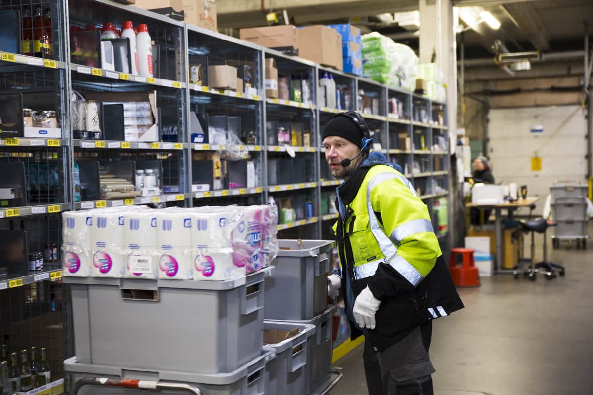 Työntekijä Pasi Rutanen pakkaa verkkokauppaostoksia Kauppahalli 24 logistiikkakeskuksessa Keravalla