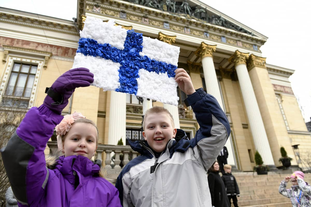 Miina Urpilainen (vas.) ja Miro Kinnunen esittelevät pääministeri Juha Sipilälle tekemäänsä korttia ennen juhlaa.