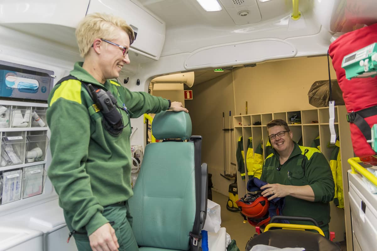 Tarja Matilainen ja Heikki Palojärvi ensihoidon autohallissa tarkistamassa ambulanssia