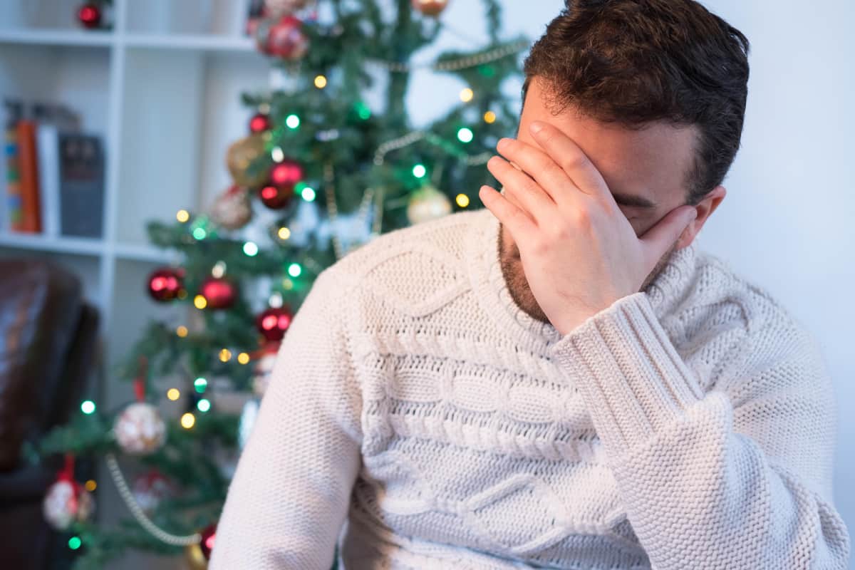 Ahdistunut, stressaantunut mies jouluna alla.