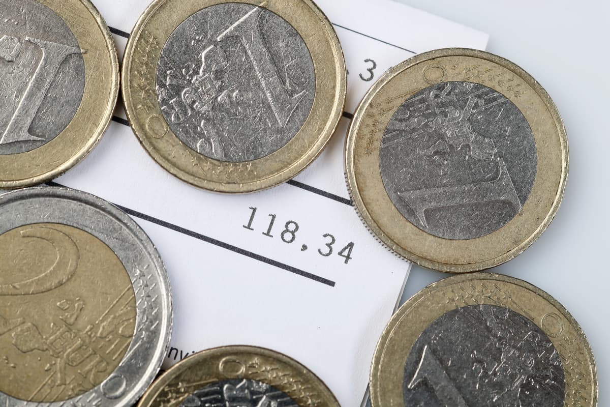 En hög med mynt ovanpå en räkning på 118 euro.