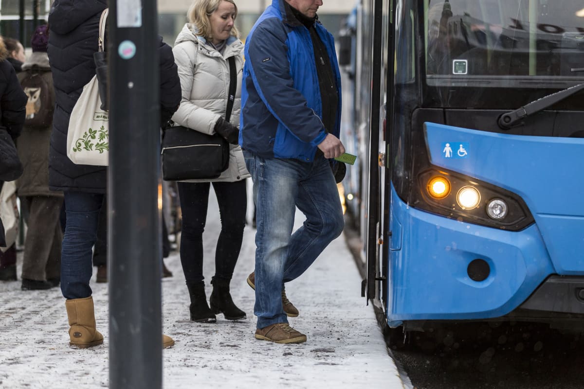 Ihmisiä nousemassa bussin kyytiin Helsingissä.