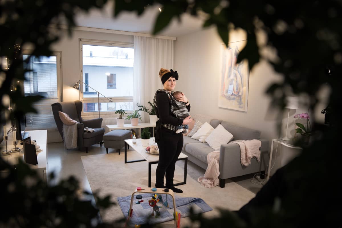 Iida Åfeldt vauva sylissä olohuoneessaan.