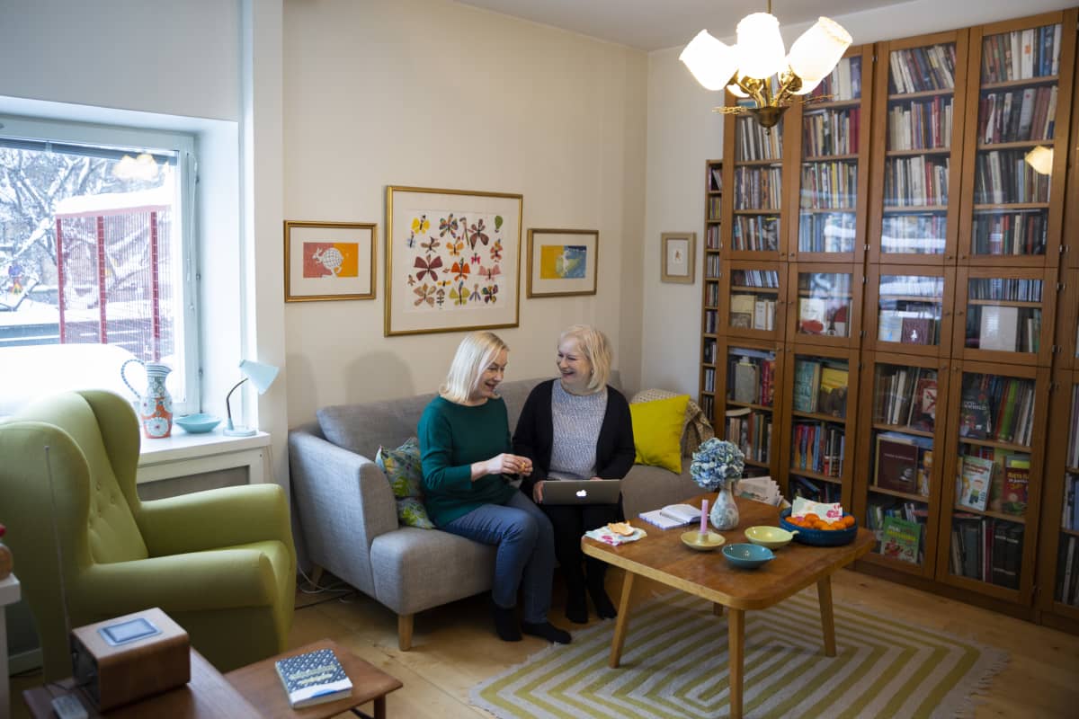Tiina ja Sinikka Nopola työskentelevät sohvalla.