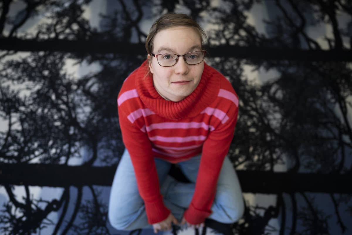 Jenny Kärkkäinen istuu olohuoneen lattialla.