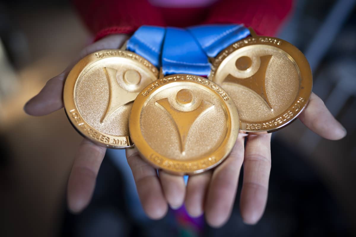 Lähikuva olympiamitaleista kädessä.