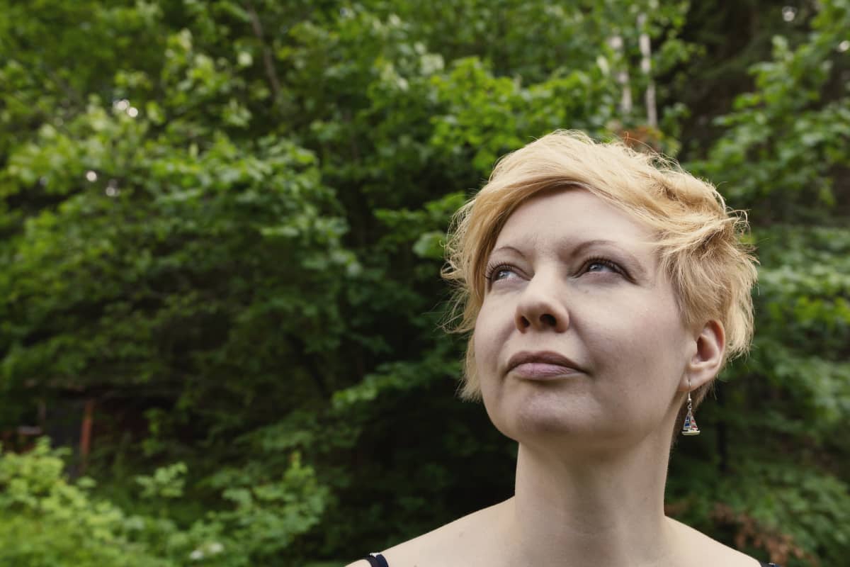 Kirjailija Marianna Kurtto saa tallustaa paljain jaloin taiteilijaresidenssin nurmella.