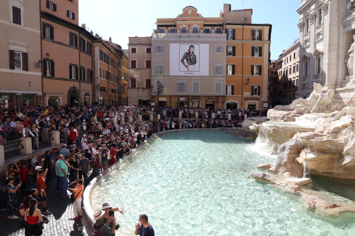 Turisteja Fontana di Trevin suihkulähteellä Roomassa