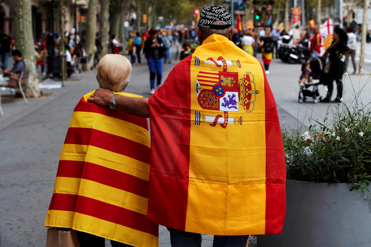 Mies ja nainen ovat sitoneet harteilleen Katalonian ja Espanjan liput.
