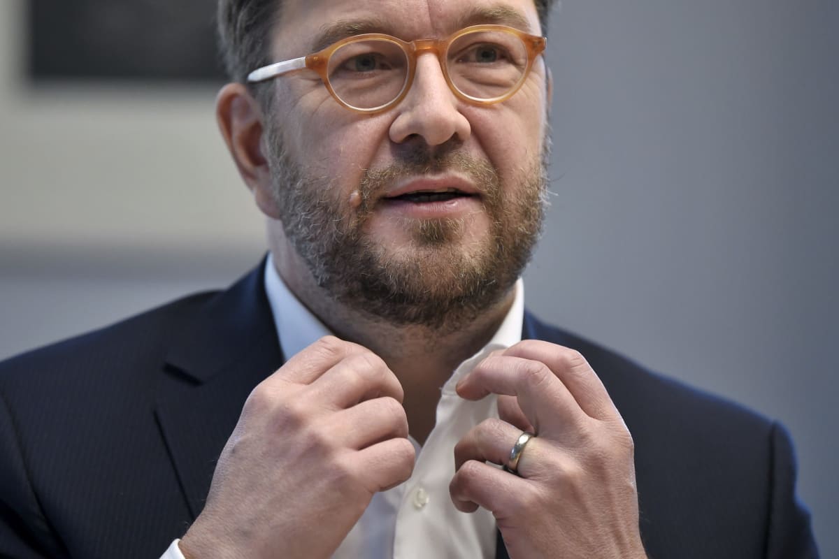 Minister Harakka förklarar, med händerna uppe.