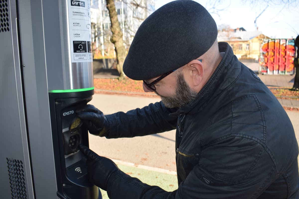 Tuotepäällikkö Kimmo Kuusinen esittelee sähköauton latausasemaa.