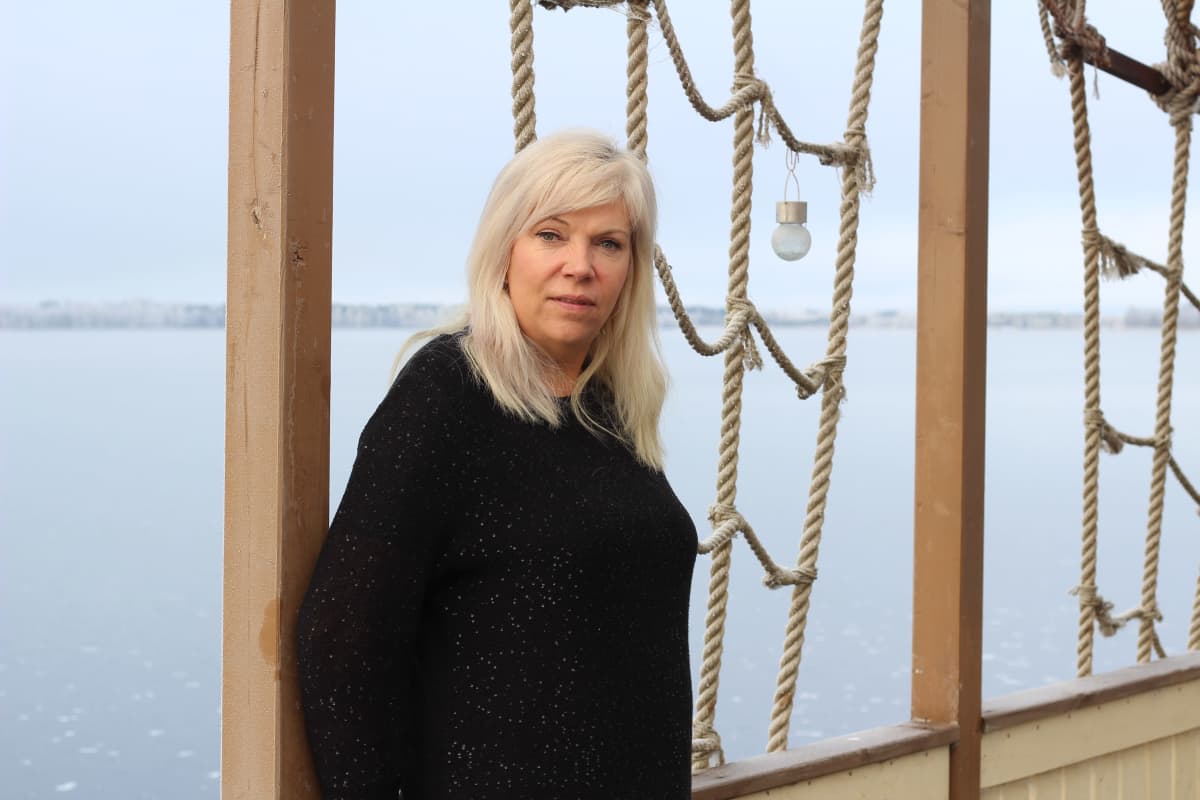 Natalia Alaspää terassilla, taustalla talvinen järvi.
