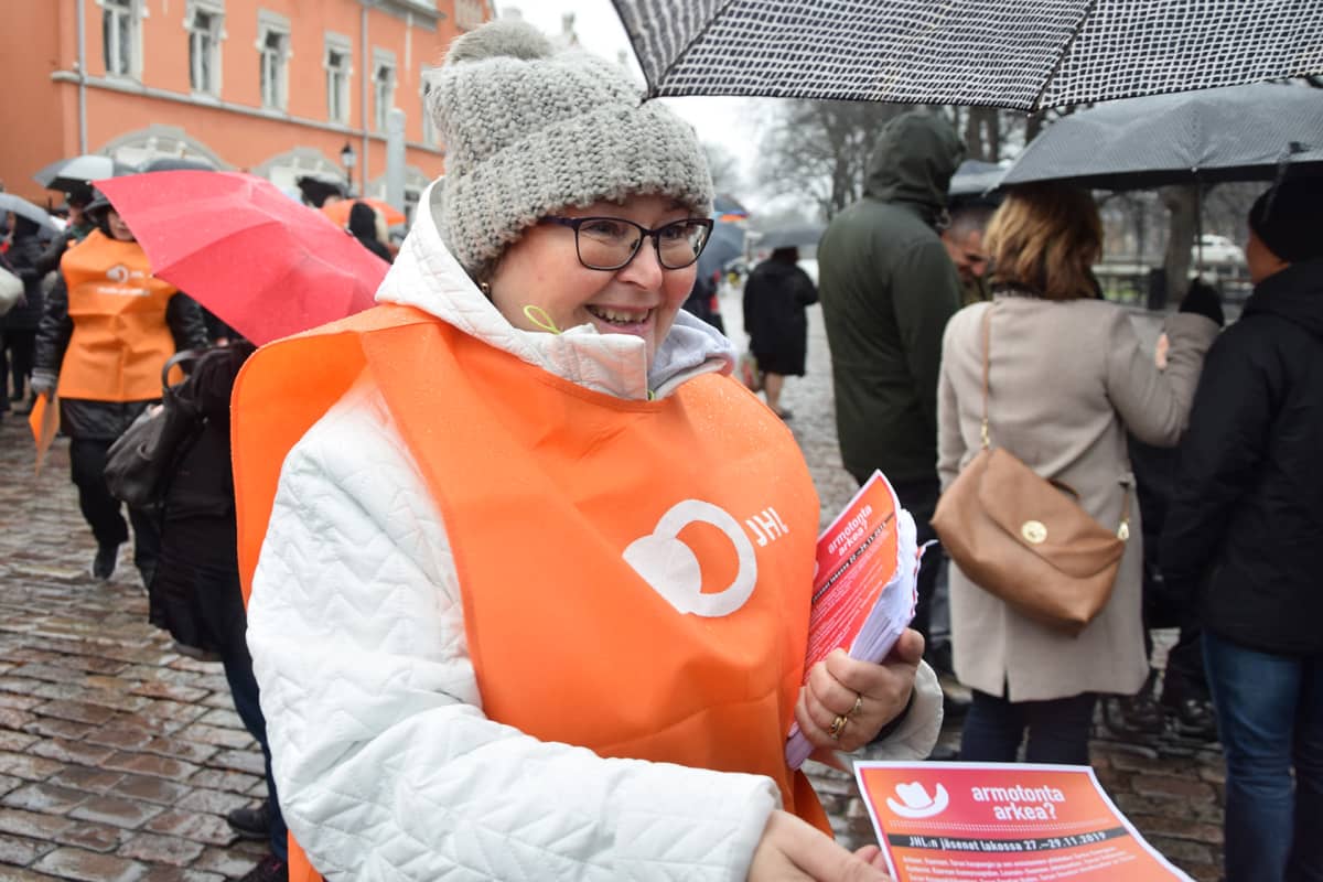 Maaret Laakso jakaa esitteitä JHL:n mielenilmauksessa Turun Vähätorilla.