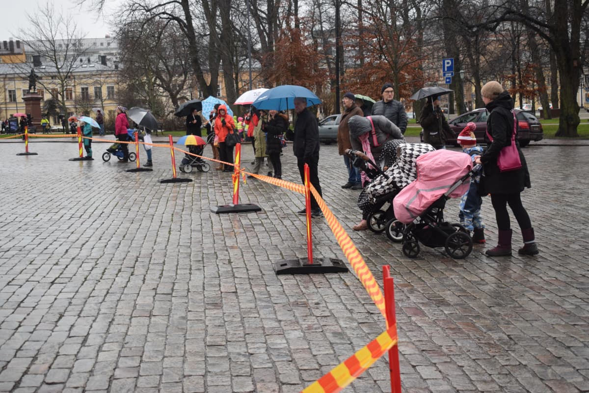 Yleisö katsoo joulukuusta Turun tuomiokirkon edessä.