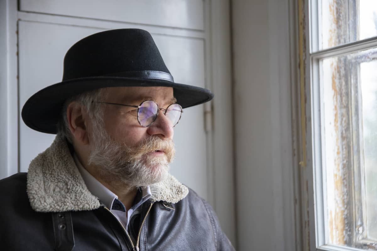 Pasi Lehti katsoo ulos ikkunasta Hajalan koulurakennuksen yläkerrasta.