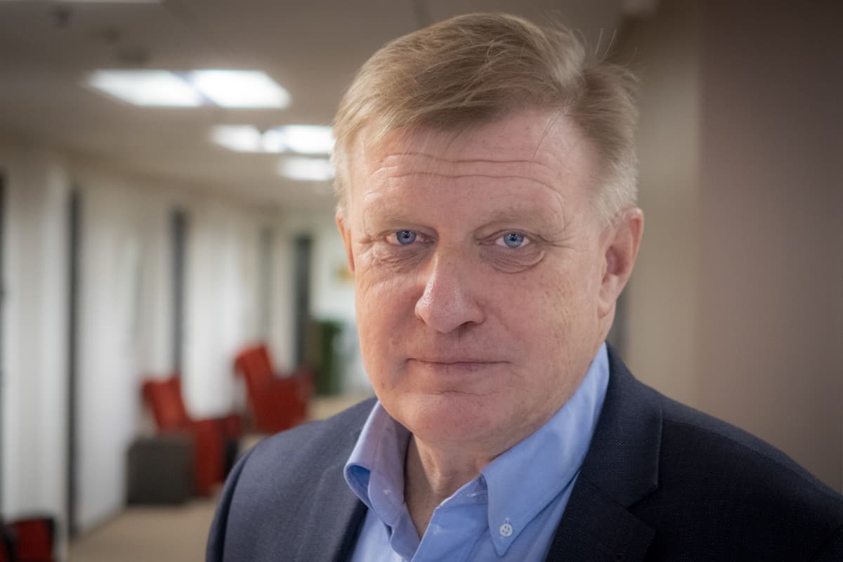 Pasi Virtanen lähikuvassa toimiston käytävällä
