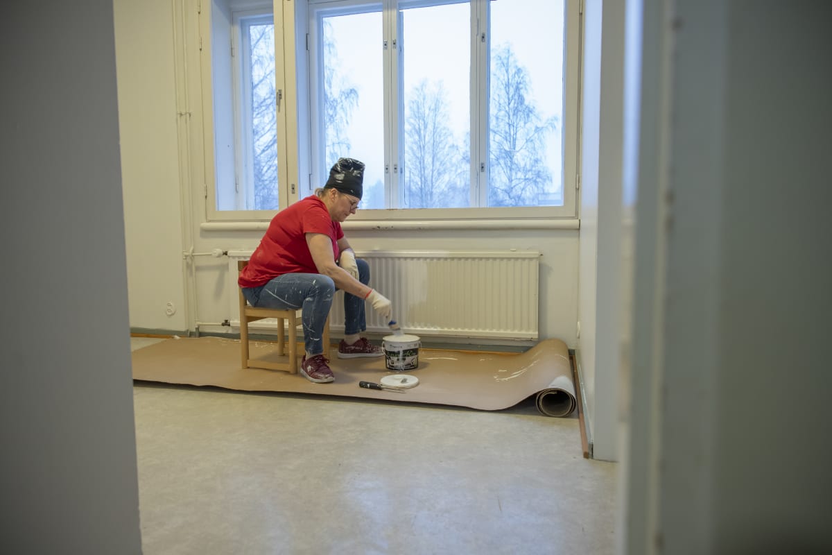 Minna Torkkola maalaa huonetta.