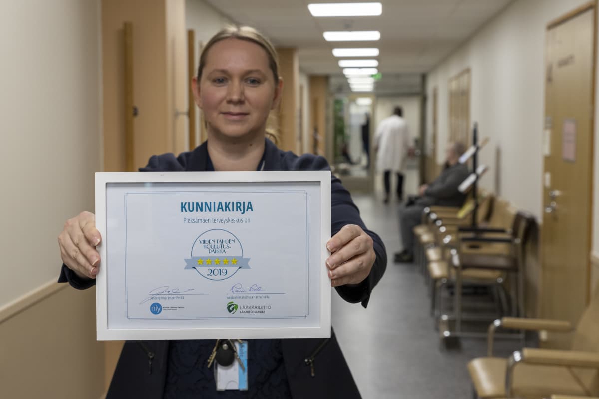 Pieksämäen sairaalan johtava ylilääkäri Aino Rubini näyttää sairaalalle myönnettyä kunniakirjaa. Siinä lukee: Pieksämäen terveyskeskus on viiden tähden koulutuspaikka.