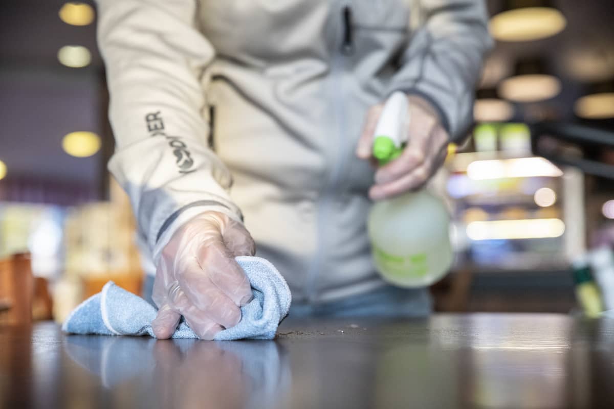 Anu Hokkanen siistii pöytiä työpaikallansa