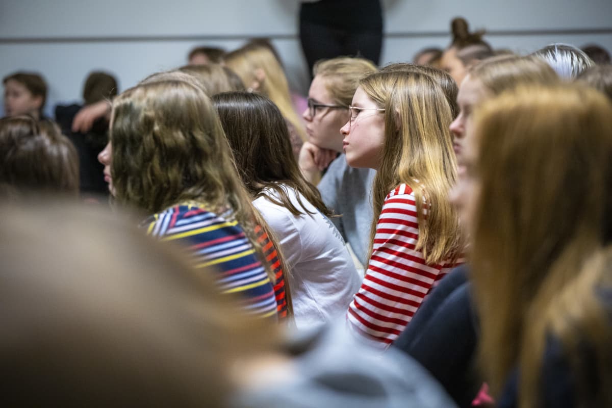 Oppilaita kuuntelemassa Jyri Paretskoita Minna Canthin koulun liikuntasalissa