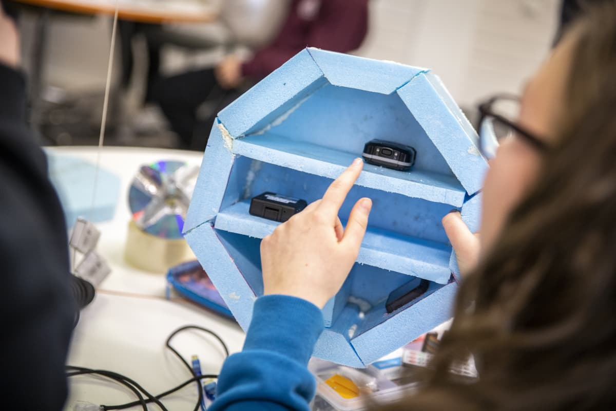 Oppilaat tarkastelevat laatikkoa, joka lähetetään avaruuteen.
