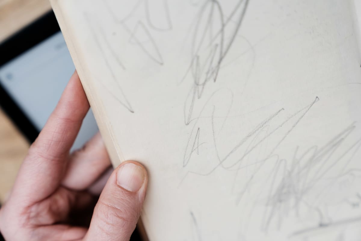 Väitöskirjatutkija Anna Kajander selailee lempikirjansa sivuja, joille joku on aikanaan piirrellyt.