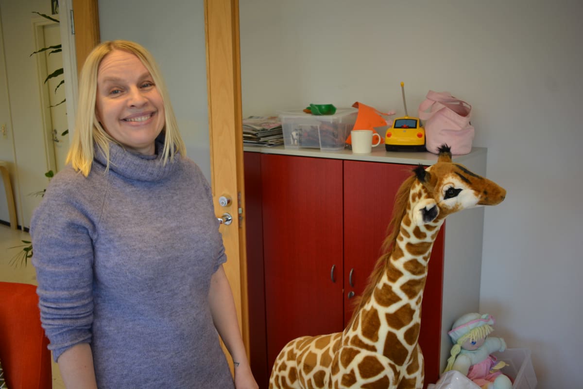 Riitta Rämö Nuorten Ystävistä maskottikirahvin kanssa.