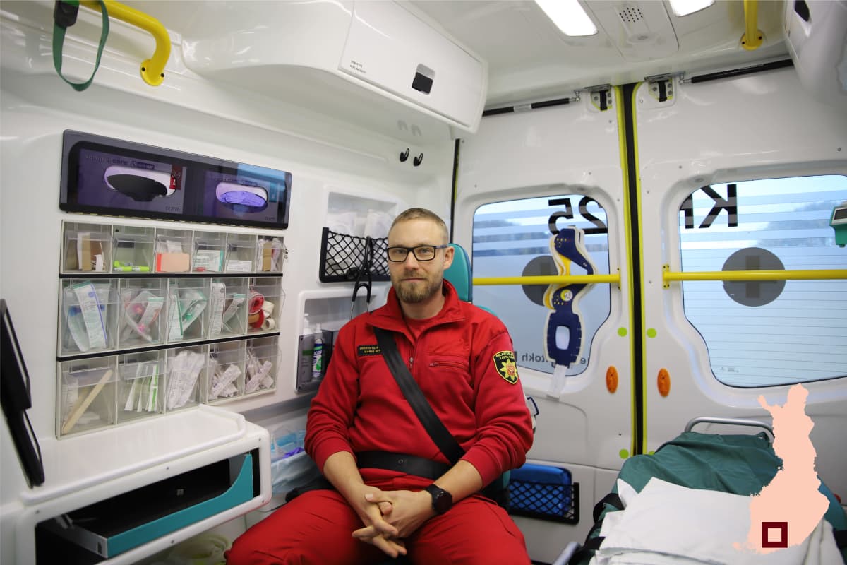 Ensihoitaja Marko Mikkonen istuu ambulanssissa.