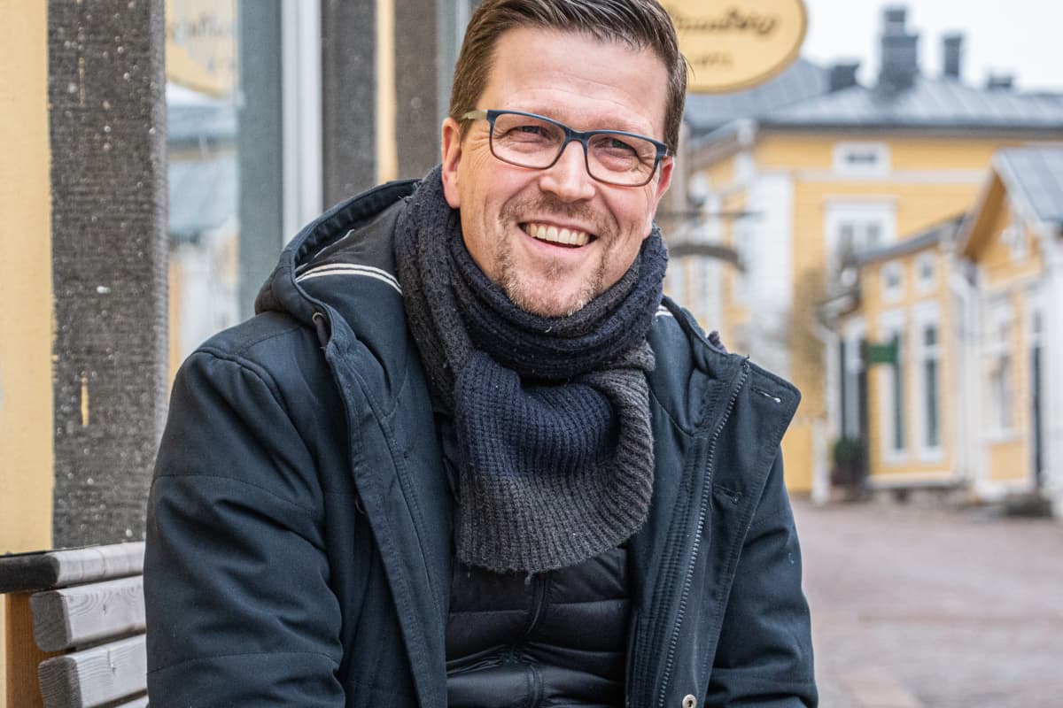 Klaus Härö sitter på en bänk och är glad