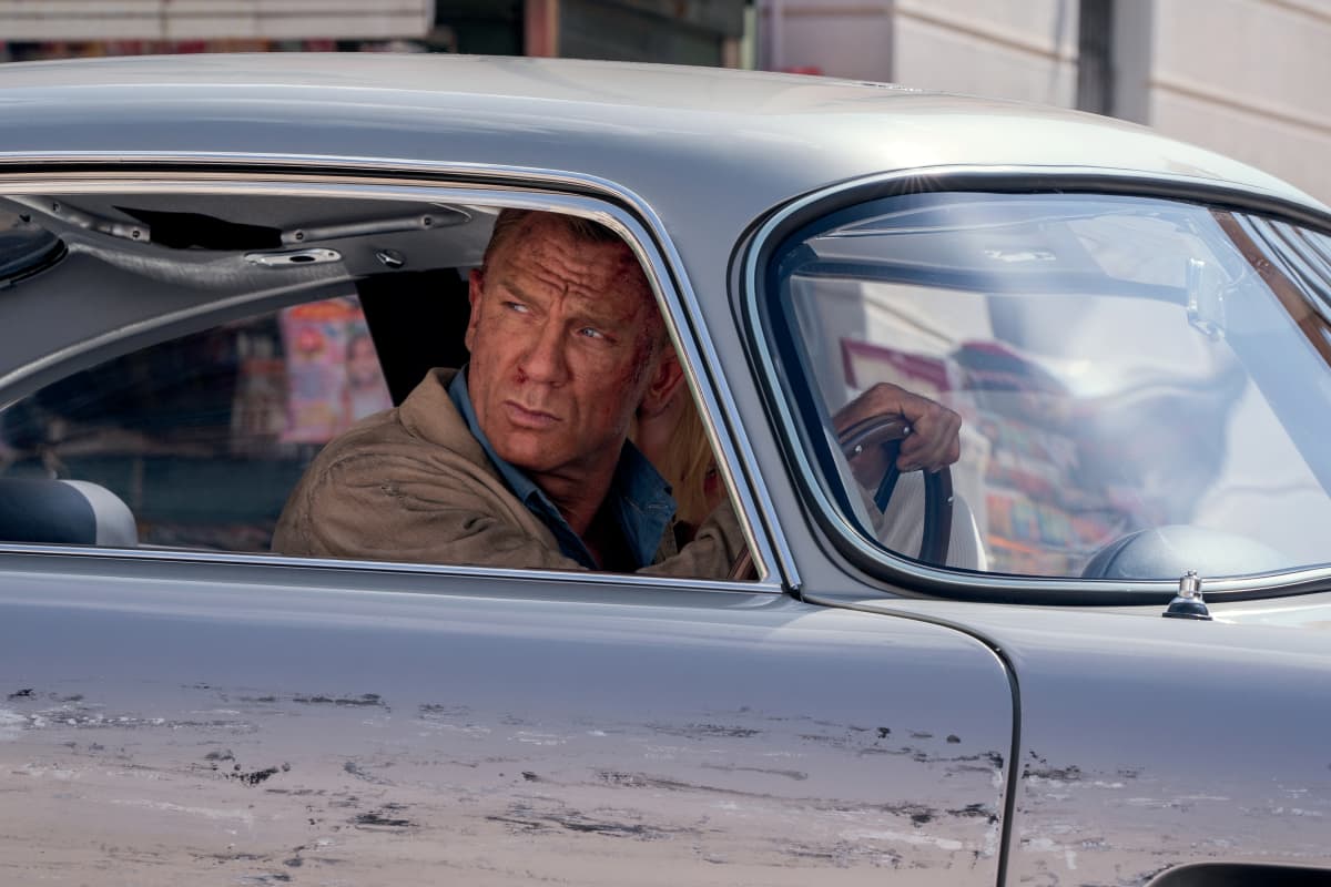 Närbild på James Bond (Daniel Craig) som kör bil och ser bekymrad ut.