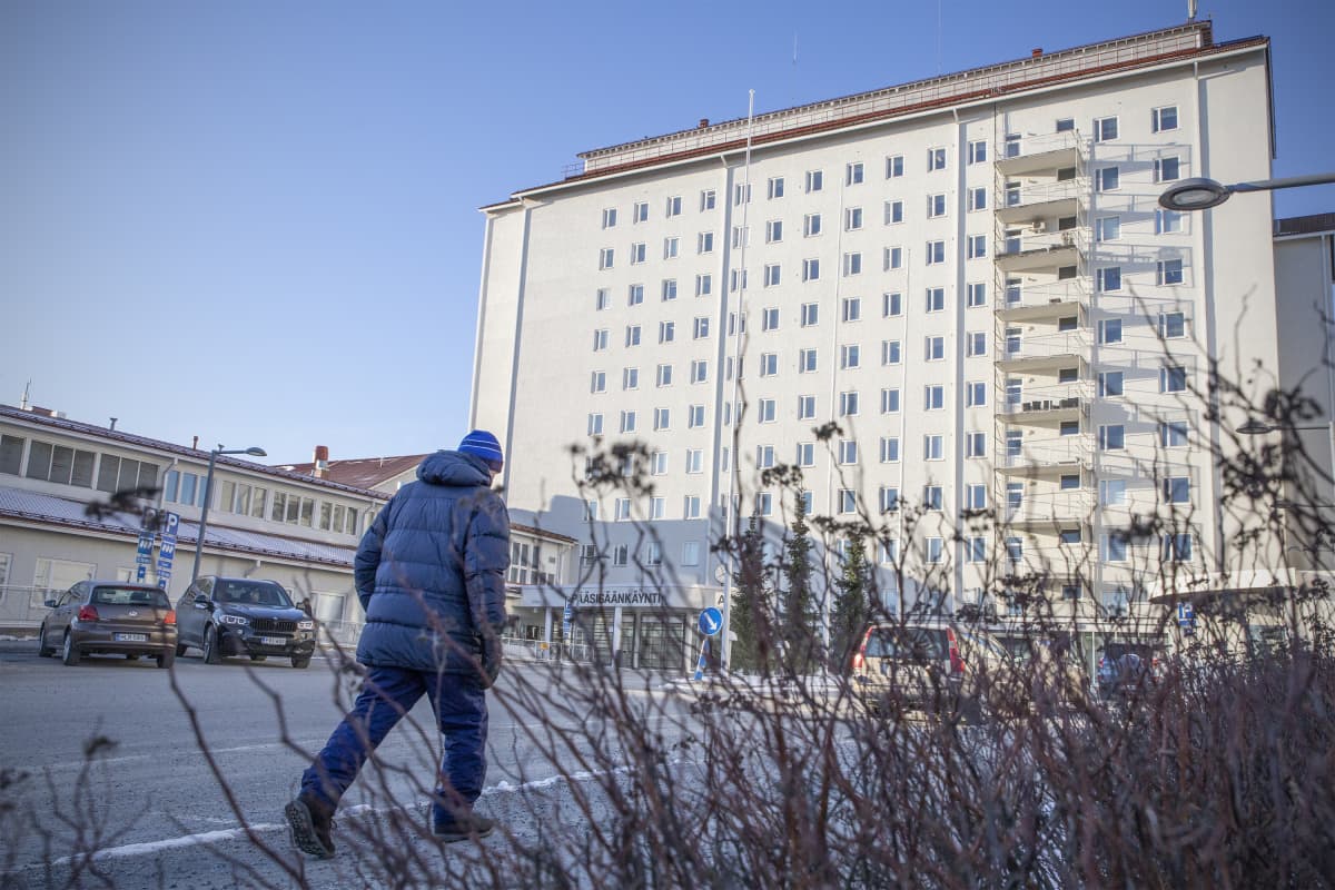 Ihminen kävelee kohti Pohjois-Karjalan keskussairaalan päärakennusta.