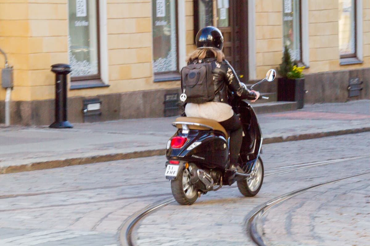 Skootteria ajava nainen Helsingin Unioninkadulla.