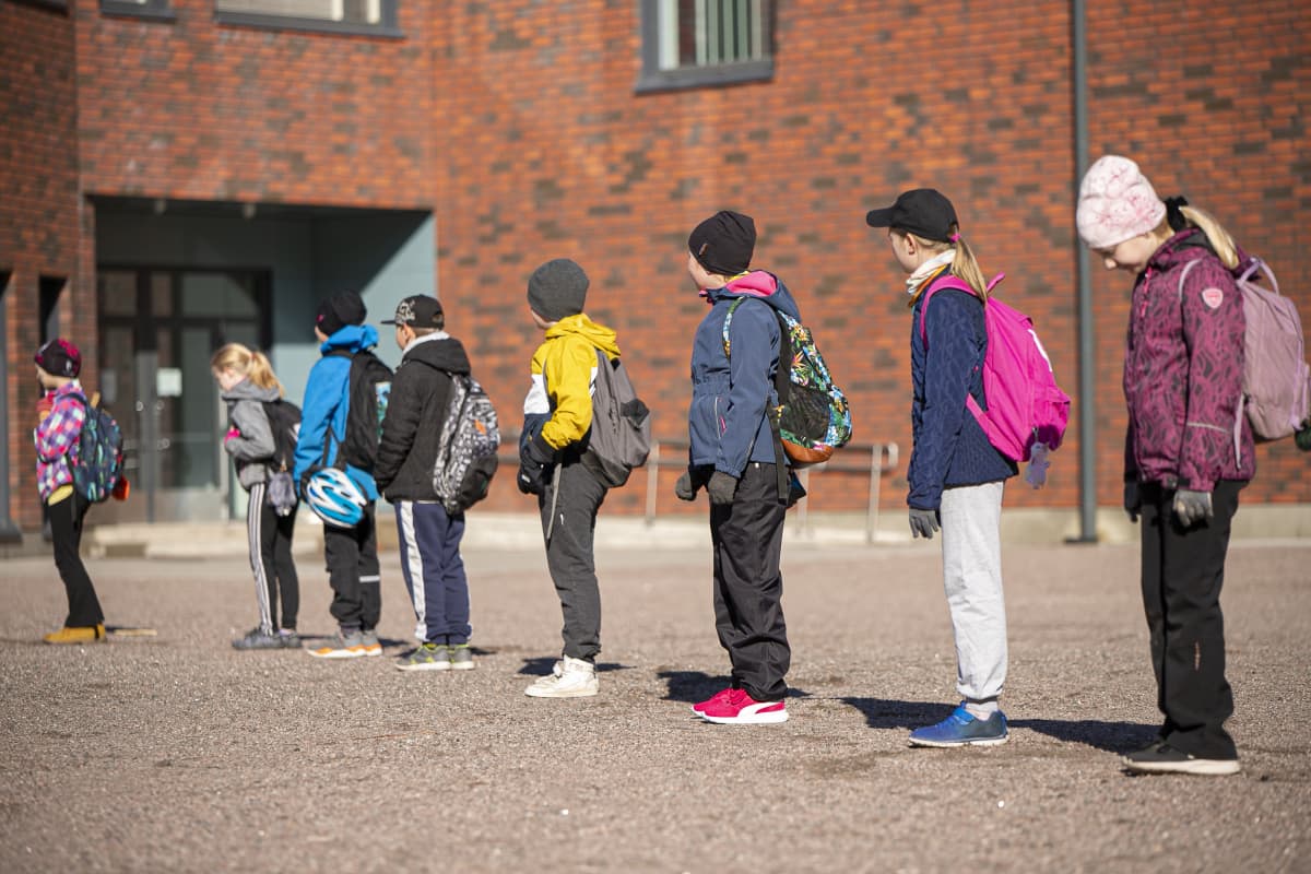 lapsia turvaväleissä koulun pihalla