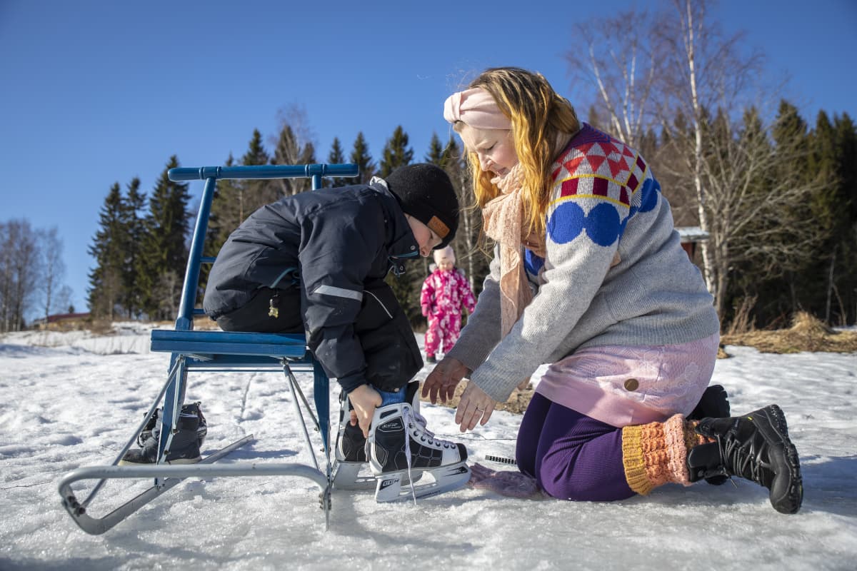 Riina Pirskanen auttaa hänen lapsellensa, Jaakolle luistimia jalkaan