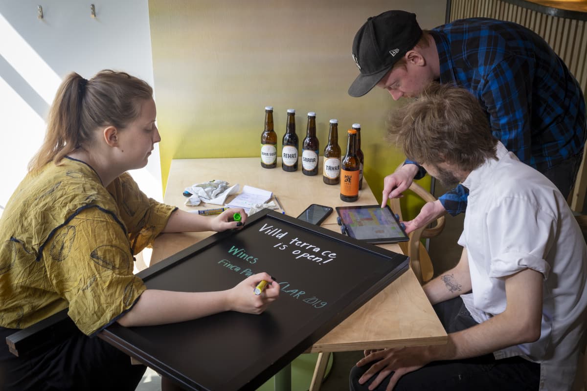 Valentina Vilhunen kirjoittaa mainoskylttiä ravintola Villdissä.
