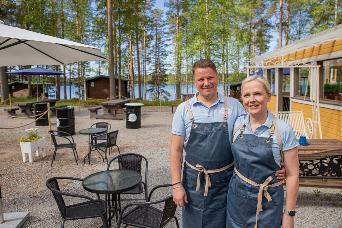 Jukka Vuorela ja Minna Luoma-aho poseeraavat leirintäalueen pihalla.