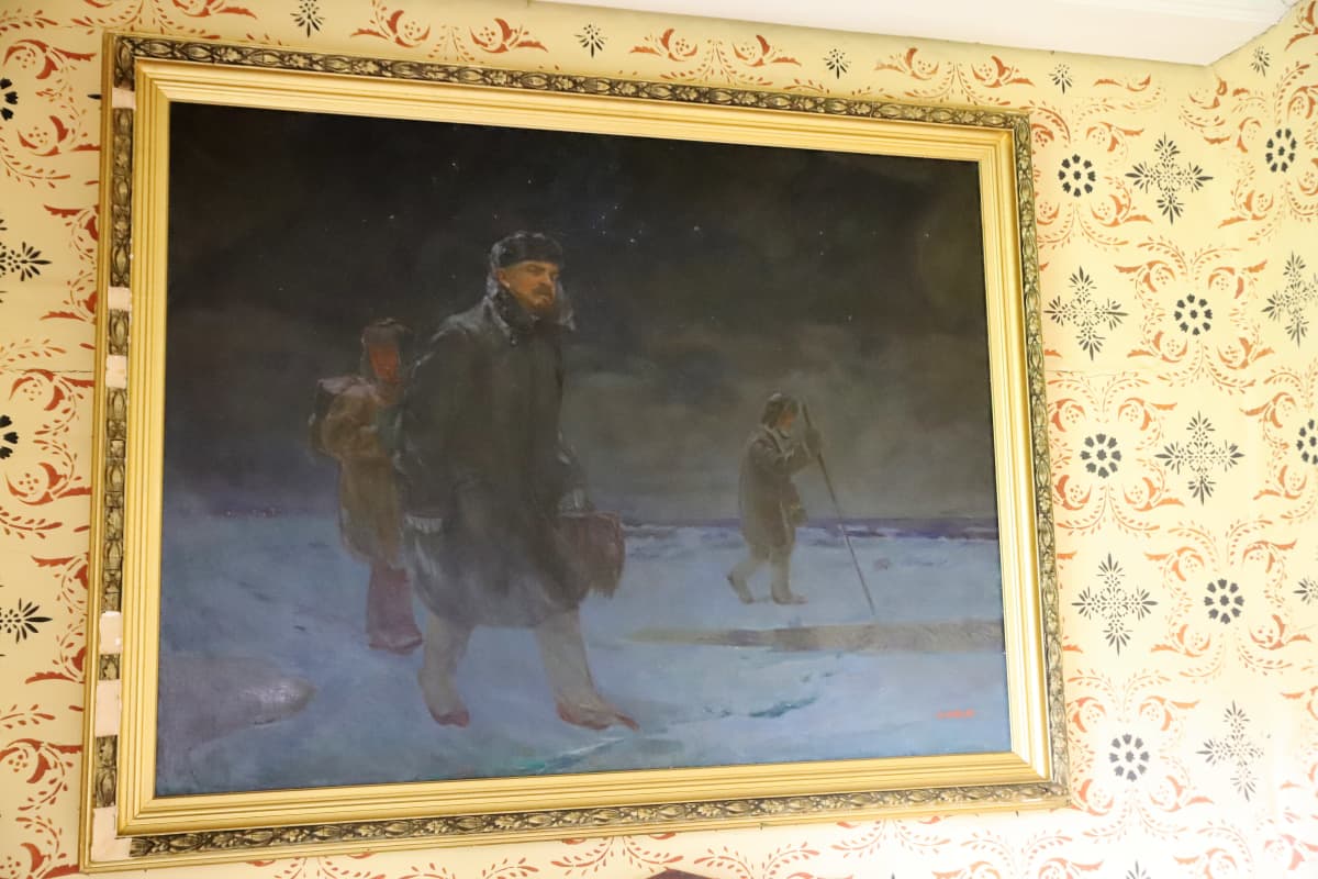 taulu Lenin kulkee jäällä Nauvossa kahden avustajan kanssa