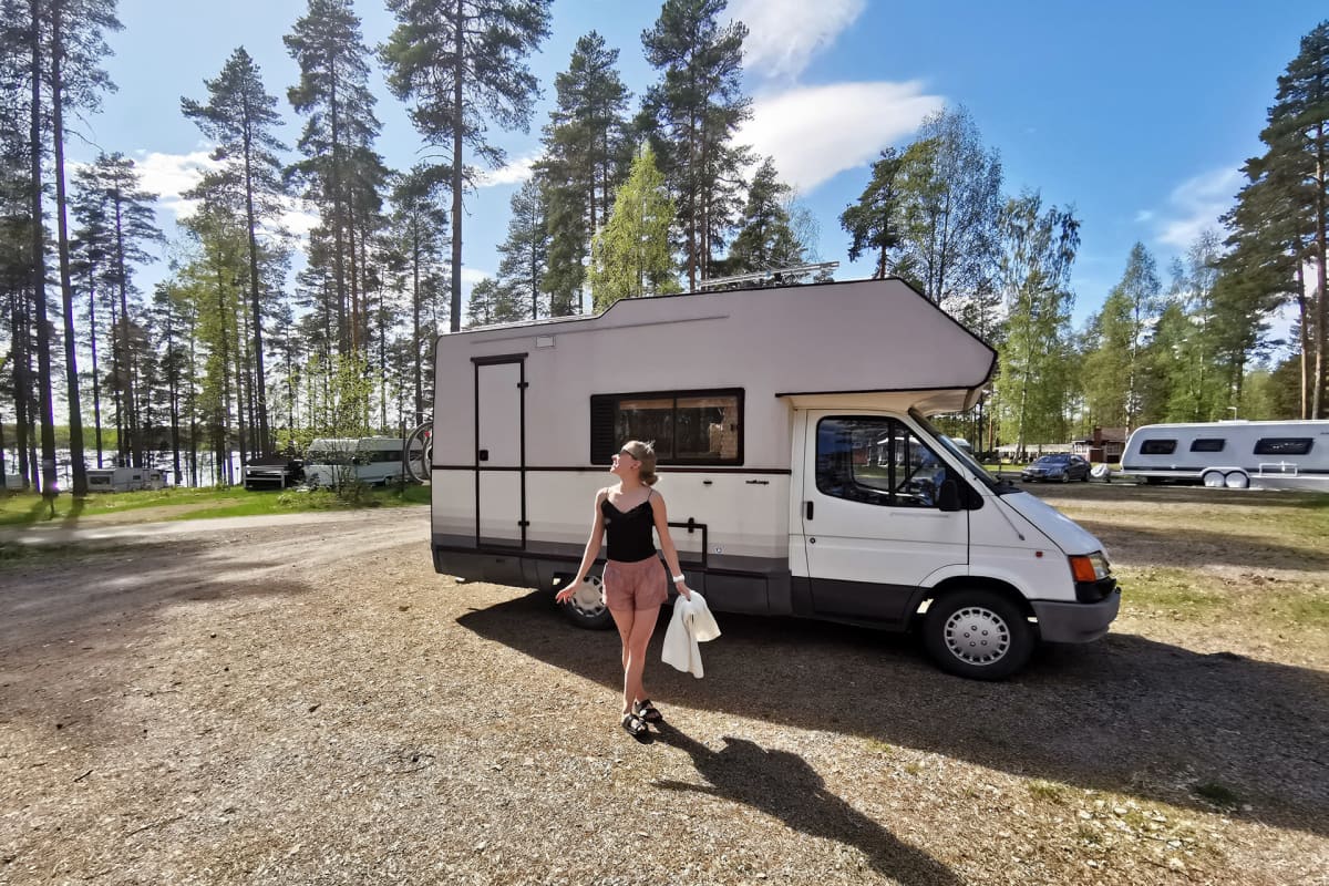 Anni Vilkki poseeraa asuntoautonsa edessä.