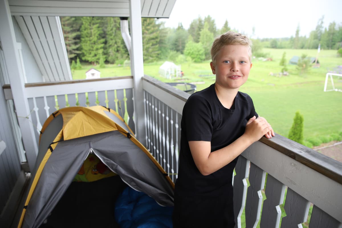 Leo Ampuja parvekkeellaan teltan vieressä.