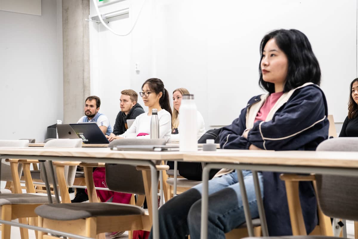Aalto-yliopiston kesäkurssin opiskelijoita luokkahuoneessa ja etäyhteydellä mukana muita opiskelijoita ympäriä Suomean ja muuta maailmaa.
