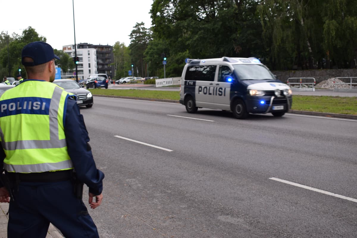 Vanhempi konstaapeli Joonas Baarman katsoo, kun poliisiauto ajaa hälytykseen.