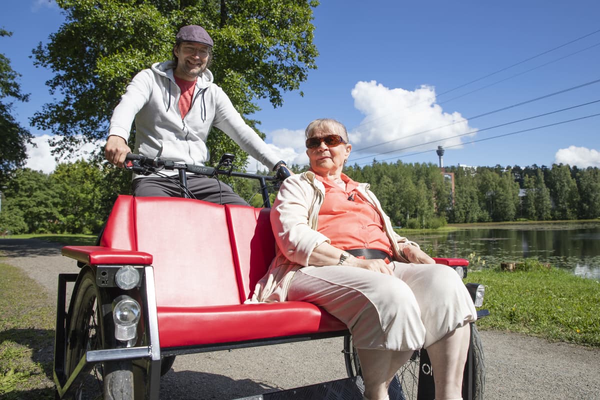 Kuopion polkijoiden puheenjohtaja Juha Hartikainen kyyditsee Helga Paavilaista riksapyörällä.