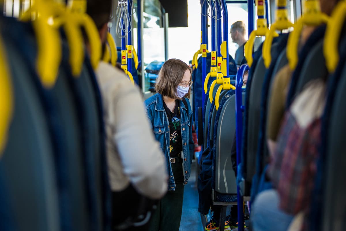 Nainen käytti kasvomaskia bussissa ensimmäisenä suosituspäivänä 14. elokuuta.