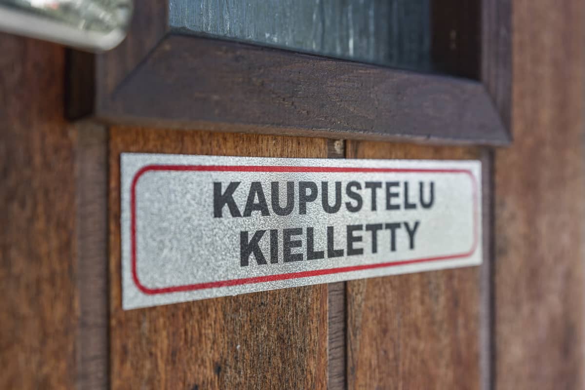 Kaupustelu kielletty kyltti ovessa.