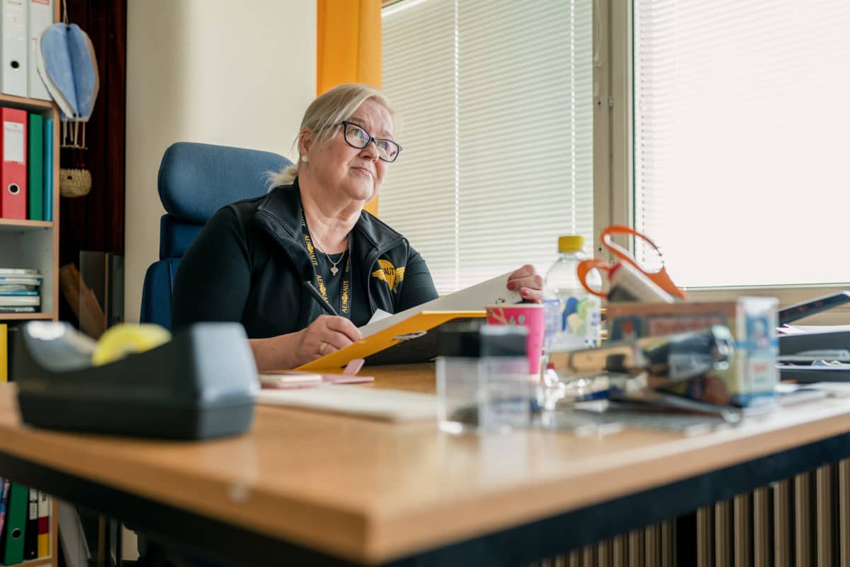 Seija Sipinen tekemässä paperitöitä työpaikallaan.