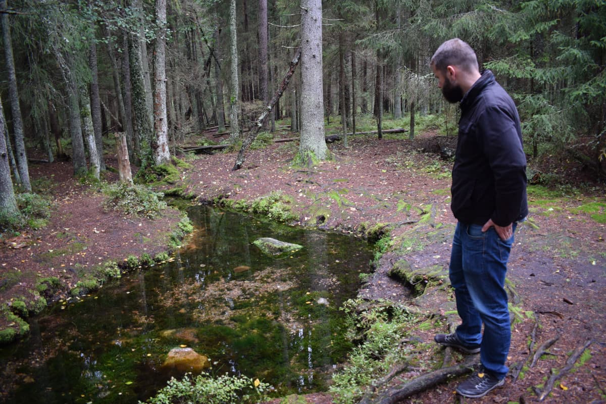 Väitöstutkija John Björkman katsoo Somerojan lähdettä Halikossa.